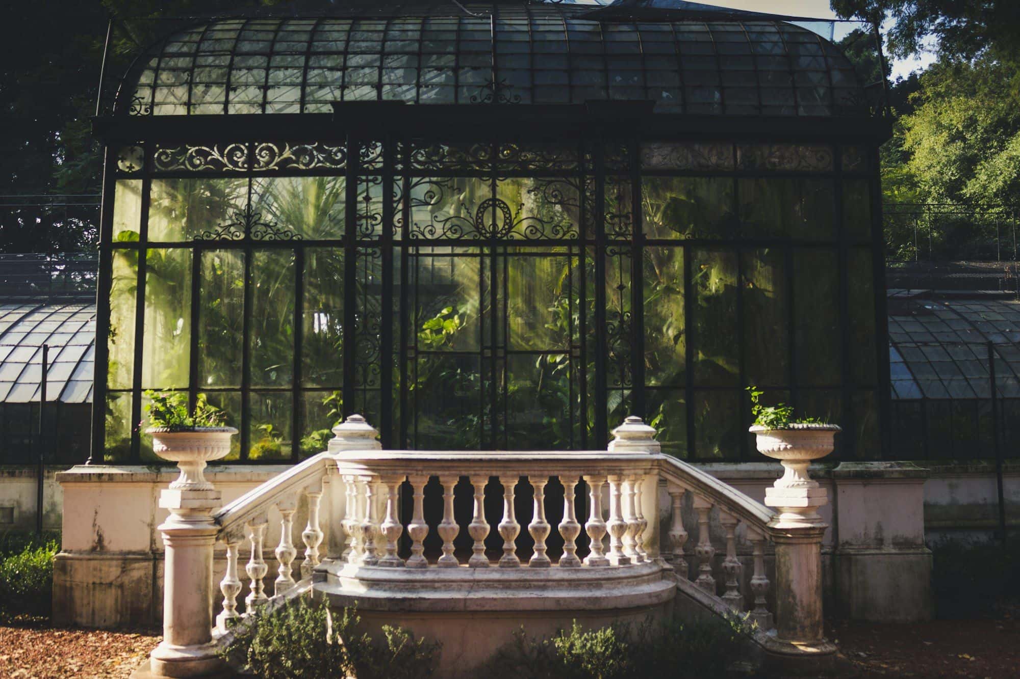 Historic glass conservatory with an ornate balustrade in front of it