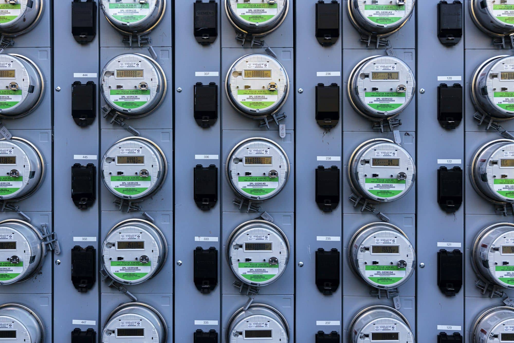 Rows of digital electricity meters mounted on a wall